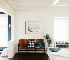 a living room with white walls and wood floors