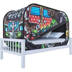 a bed with a cartoon design on it and a white wooden slatted headboard