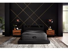 a black bedroom with gold lines on the wall and an upholstered bed frame