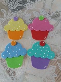 three decorated cupcakes sitting on top of a lace doily