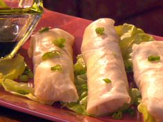 three burritos on a plate with lettuce and garnishes