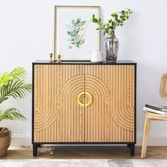 a wooden cabinet sitting next to a potted plant on top of a hard wood floor