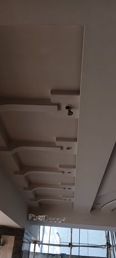 the ceiling in an office building is made out of wood and white painted plasters