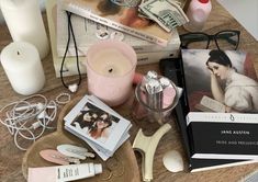 a table topped with books, candles and other personal care items on top of it