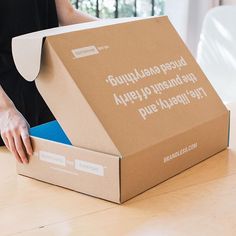 a person opening up a box on a table