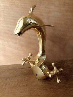 a golden dolphin statue sitting on top of a wooden table