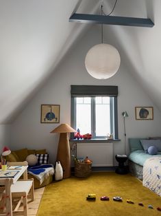 an attic bedroom with yellow carpet and toys on the floor