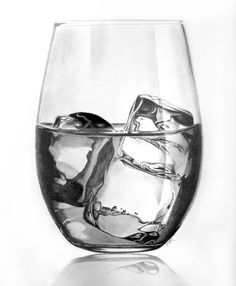 a glass filled with ice and water on top of a table