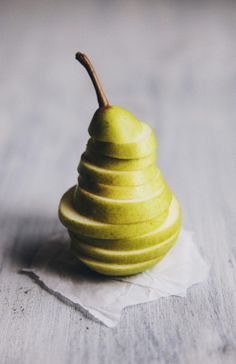 a green apple sitting on top of a piece of paper