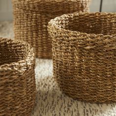 three woven baskets sitting on top of a rug