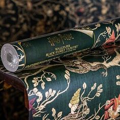 two rolls of harry potter's wands on a green and gold patterned chair