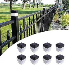 six black plastic boxes sitting on top of a white table in front of a fence