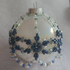 a white ornament with blue beads on it