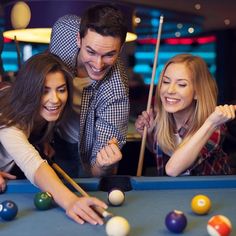 group of friends playing pool together in a bar