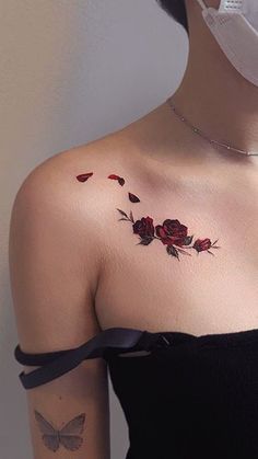 a woman's shoulder with roses and butterflies tattooed on her left side breast area