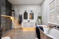 a large bathroom with two sinks and a bathtub next to a walk in shower