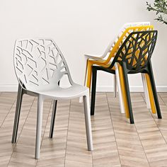 two white and yellow chairs sitting on top of a hard wood floor next to each other