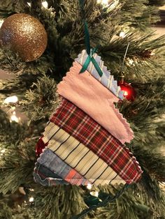 an ornament hanging from the top of a christmas tree decorated with plaid fabric