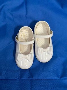 a pair of white shoes sitting on top of a blue blanket