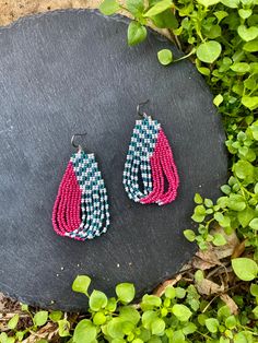 two pairs of pink and blue beaded earrings sitting on top of a slate slab