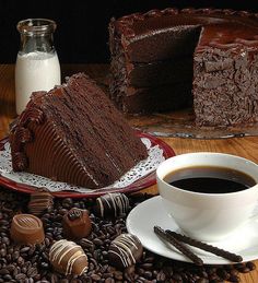 there is a piece of chocolate cake next to a cup of coffee