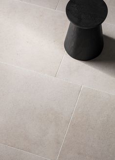 a black table sitting on top of a white tiled floor