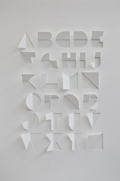 the letters are cut out of paper and placed on top of each other in different shapes