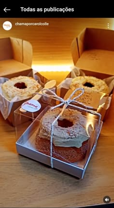 four boxes filled with cakes sitting on top of a wooden table