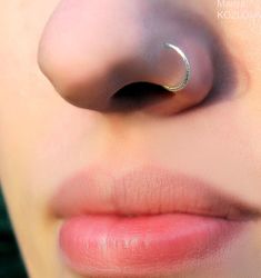 a woman's nose with a nose ring on top of her nose and the tip of her nose