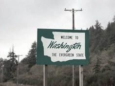 a welcome to washington sign on the side of a road