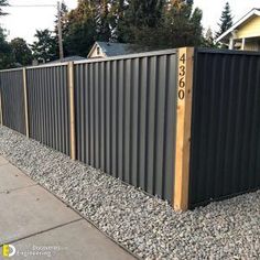 a long metal fence with numbers on the top and bottom posts in front of it