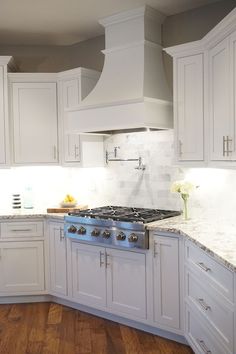 a kitchen with white cabinets and marble counter tops is pictured in this image from the front view