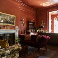 a living room filled with furniture and a fire place in front of a bar area