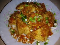 a white plate topped with fried food on top of a table