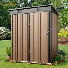 a brown storage shed sitting on top of a lush green field