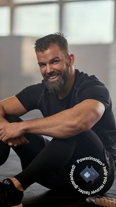 a man with a beard sitting on the ground