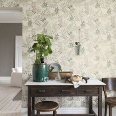 a dining room table with two chairs and a potted plant on top of it