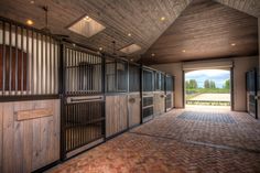 the inside of a horse stable with doors open