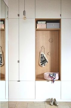 a pair of shoes sitting on top of a tiled floor next to a wooden cabinet