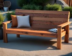 a wooden bench with two pillows on it