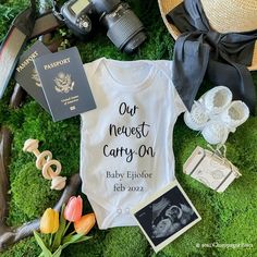 a baby's shirt with the words our greatest adventure begins on it surrounded by other items