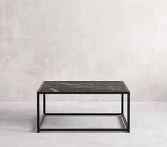 a black marble coffee table against a white wall with no one in the room looking at it