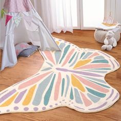 a child's room with a teepee tent and stuffed animals on the floor