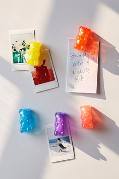 some gummy bears are sitting on a table next to an envelope and two photos