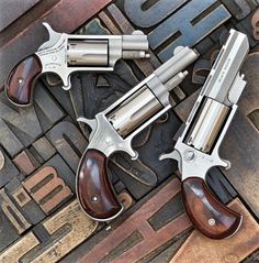 three revolvers sitting on top of each other in front of some type of sign