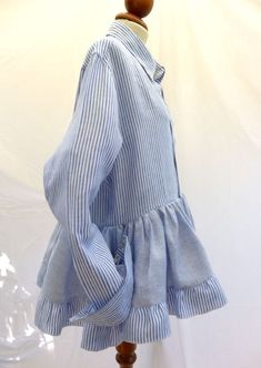 Cool Repurposed Peplum with Button Down Collar & Flounces made from 2 Vintage Linen Men's Shirts. Using only pristine vintage clothing, I mix up the mix, interchanging parts from several garments to reconstruct  a new spin on a fresh design.  The finished shirt is made from two different linen shirts (one Baby Blue & White stripes the other Baby Blue and White mini checks)  from my husbands hand me downs. I have re stitched the Sleeves and cuffs to suit a women's body. This Shirt is Loose, Cool and Breezy for those hot Summer days.   Buttoned cuffs and Button Down Collar. Buttons closure. Sizes - Fits Small Medium and Large. Material and Care:  Material information: 100% Linen 40oC coloured wash Do Not Bleach Do Not Tumble Dry Iron Medium Heat Each shirt is a one of a kind.  All garments a Long Sleeve Ruffled Shirt With Relaxed Fit, Relaxed Fit Long Sleeve Shirt With Ruffles, Long Sleeve Cotton Tops With Covered Buttons, Cotton Long Sleeve Tops With Covered Buttons, Button Up Shirt Upcycle, Reworked Button Down, Women Shirt Designs, Hand Me Downs, Reconstructed Clothing