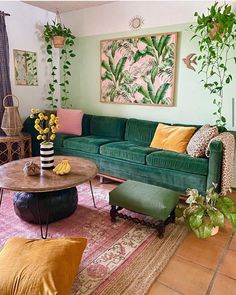 a living room filled with green couches and colorful pillows on top of a rug