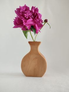 a wooden vase with pink flowers in it