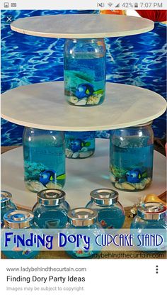 three tiered cake stand with fish in the bottom and blue water below it on display