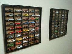 there are two pictures on the wall with toy cars in them and one has a black frame